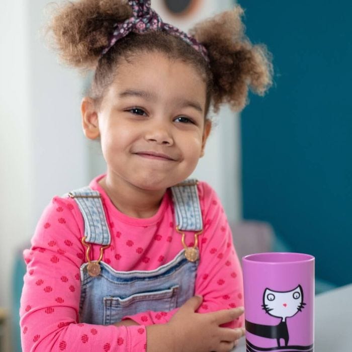 Girl playing with a No Knock cup in foreground