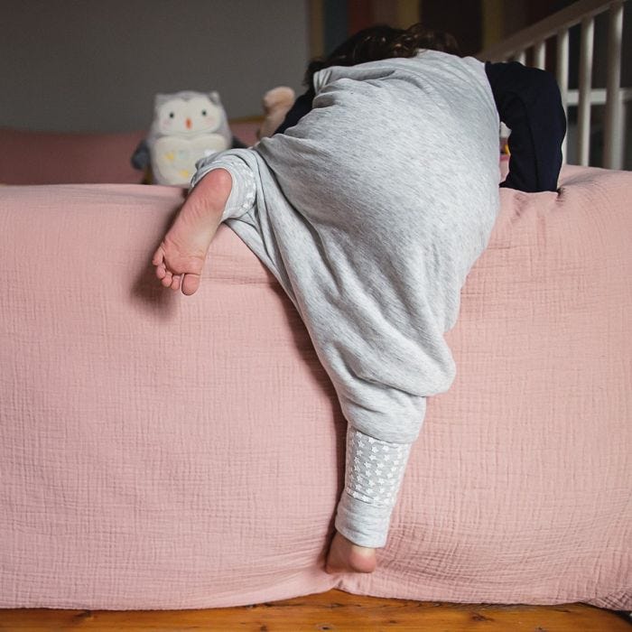 Child climbing while wearing The original grobag grey marl steppee