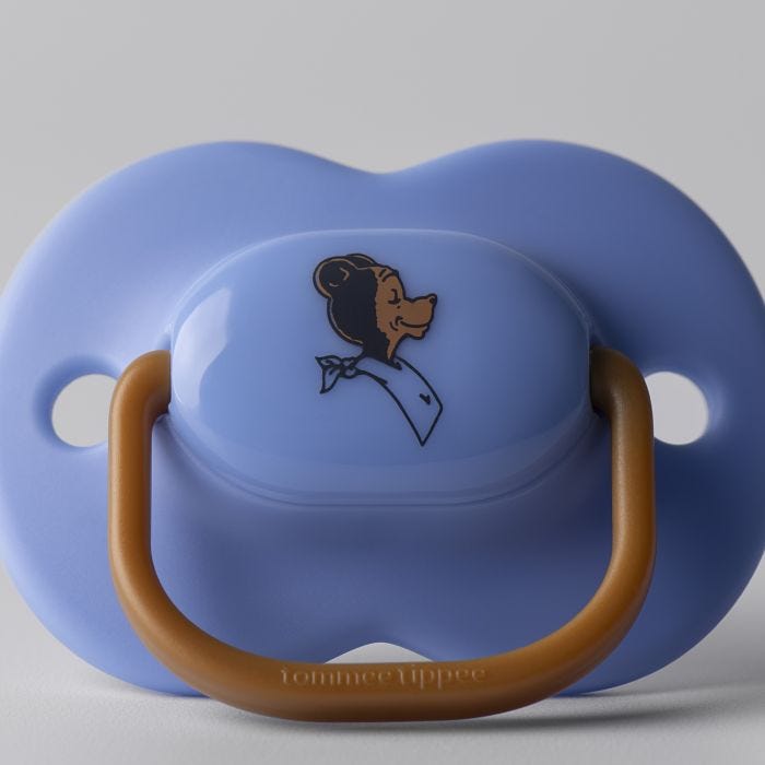 Close up image of an anytime soother against a grey background showing the Tommee Tippee bear decoration