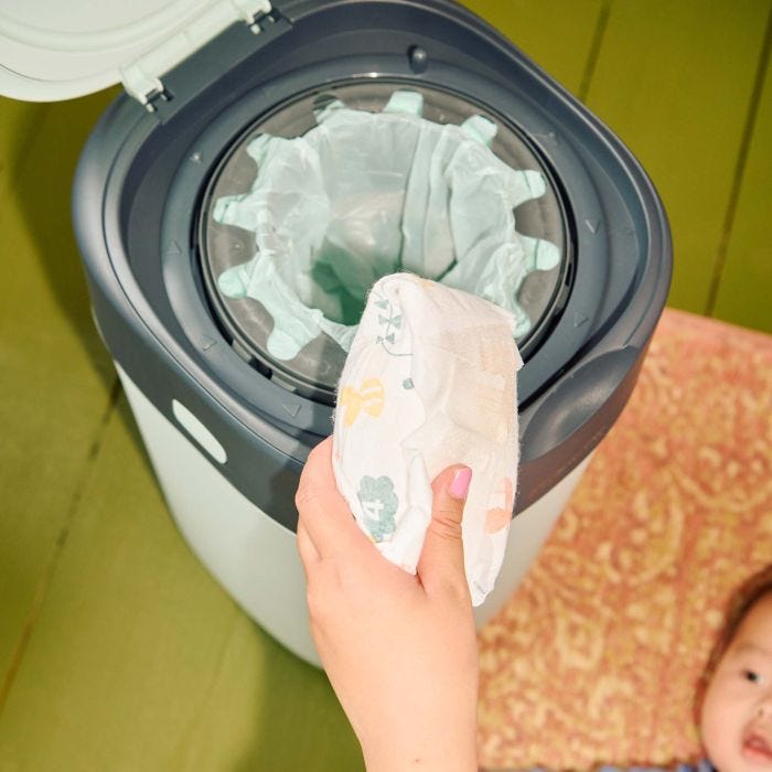 Image of a person putting a nappy into a green Twist & Click bin