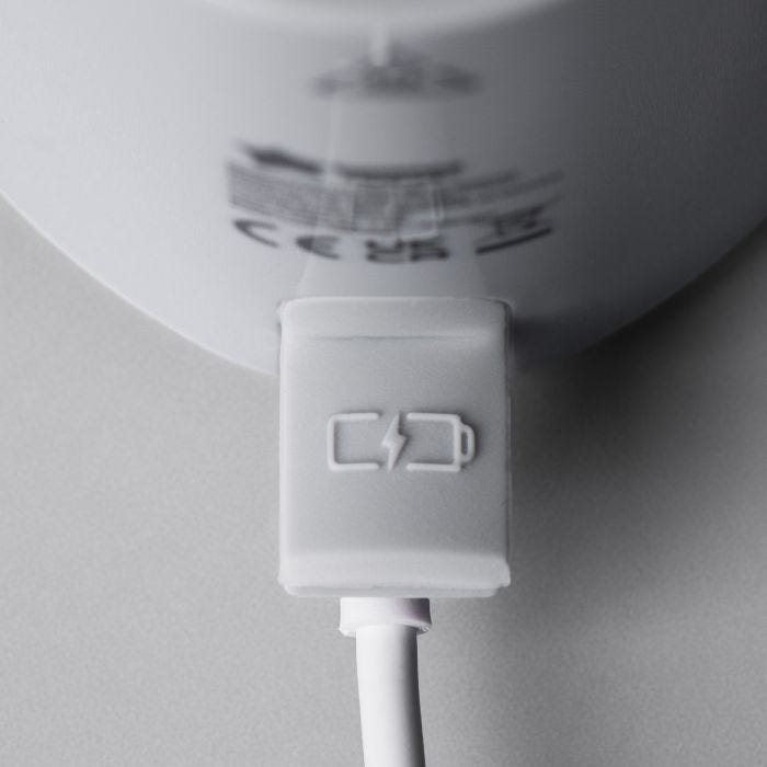 Gros plan du port de charge du chauffe-biberon portable LetsGo avec connexion USB sur un fond gris clair.