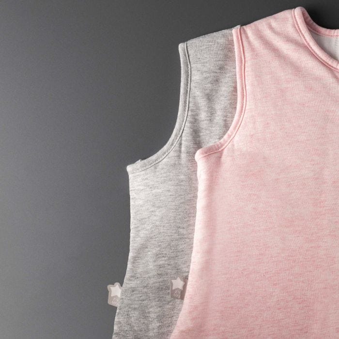 Two baby sleeping bags on a grey background