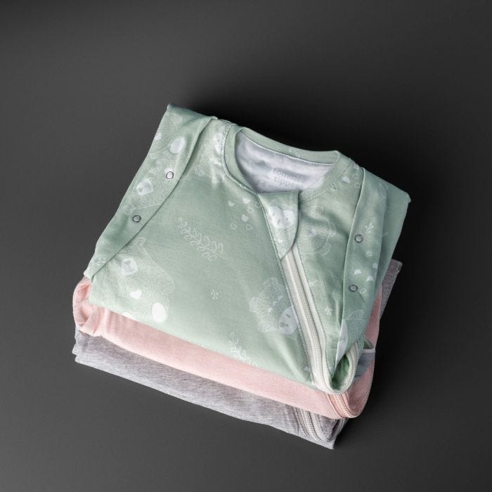 Three baby sleeping bags on a grey background