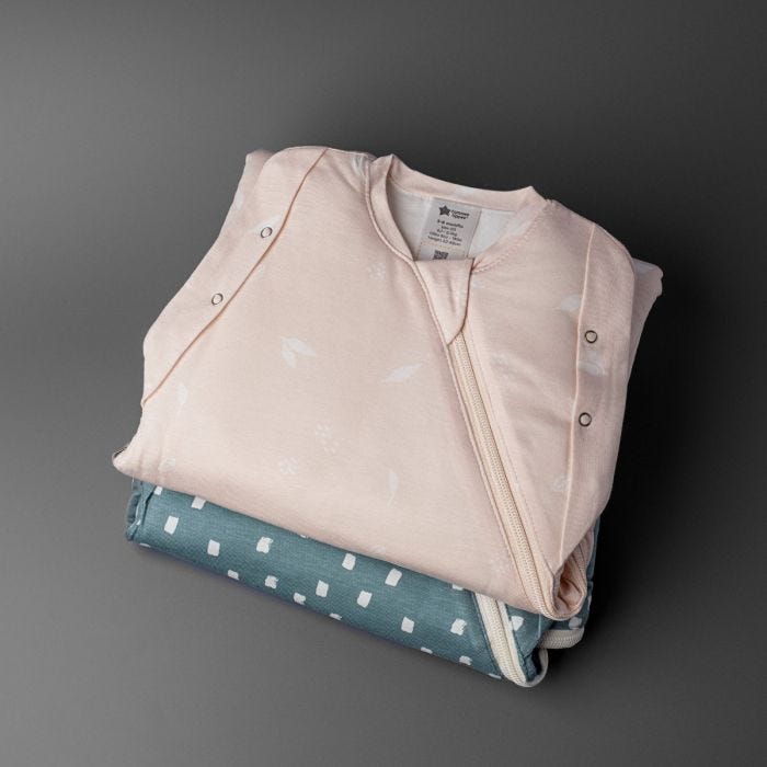 Two folded sleeping bags on a grey background