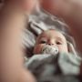 Baby with soother in mouth laying with there legs in the air