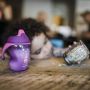 Space-girl-purple-pink-sippee-cup-on-kitchen-bench-with-toddler-playing-in-background