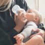 Woman feeding her baby milk from a Natural Start bottle