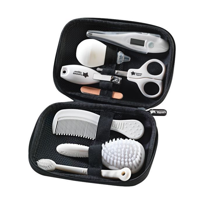 Kit de soin comprenant des accessoires pour les cheveux et les ongles dans une mallette de voyage noire sur fond blanc.