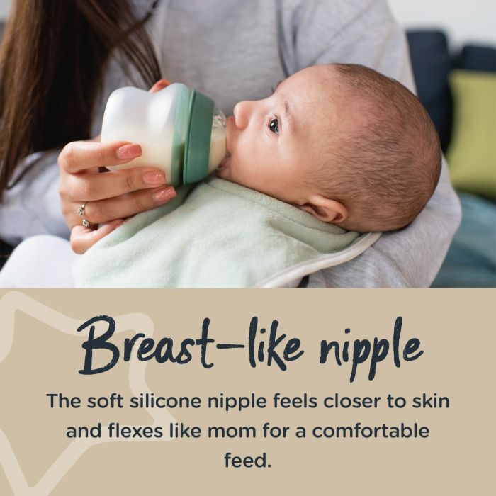 Baby drinking from silicone baby bottle with text describing the benefits of the breast-like nipple.