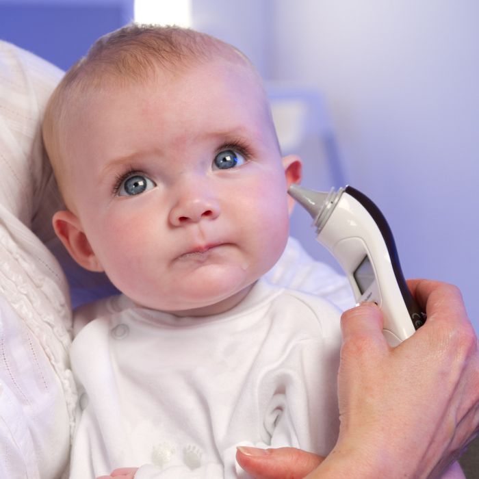 Mum using digital ear thermometer on baby 