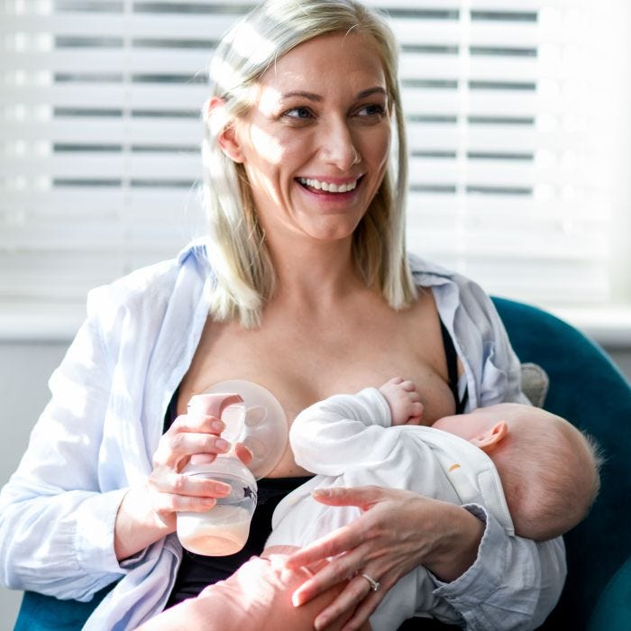 Femme utilisant un tire-lait manuel sur un sein en allaitant un bébé de l&apos;autre