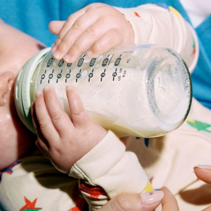 Close up of baby drinking milk from a silicone bottle