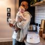 Dad holding his smiling baby and standing next to his microwave sterilizer