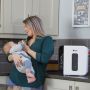 mum feeding baby with UV steriliser in foreground