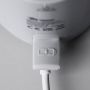 Close up of a USB connected to the LetsGo Portable Baby Bottle Warmer charging port on a light grey background
