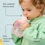 Toddler drinking from a starter straw cup against a blue background with pointers to the product key features