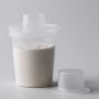 Distributeur de lait en poudre contenant du lait maternisé sur fond gris clair