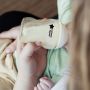 Parent feeding baby milk from a PPSU bottle