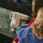 Image of a parent and toddler with a Perfect Prep machine on a kitchen counter behind them making up a feed