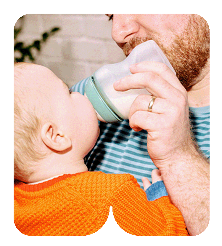 Mother feeding baby with natural start silicone bottle