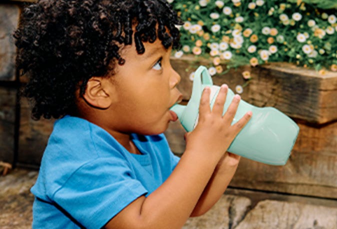 Baby outside sipping from insulated bottle 