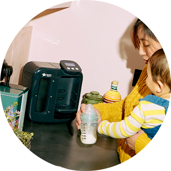 A mum feeding her baby using a tommee tippee wearable breast pump