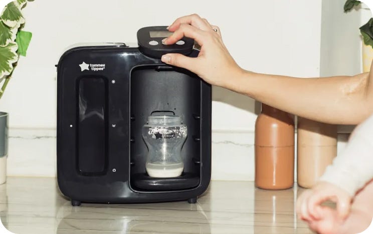 a mum making a baby bottle using a perfect prep machine 