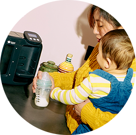 A mum feeding her baby using a tommee tippee wearable breast pump