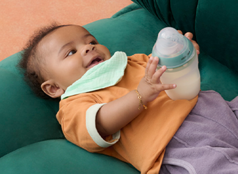 a baby holding a silicone baby bottle from Tommee Tippee 